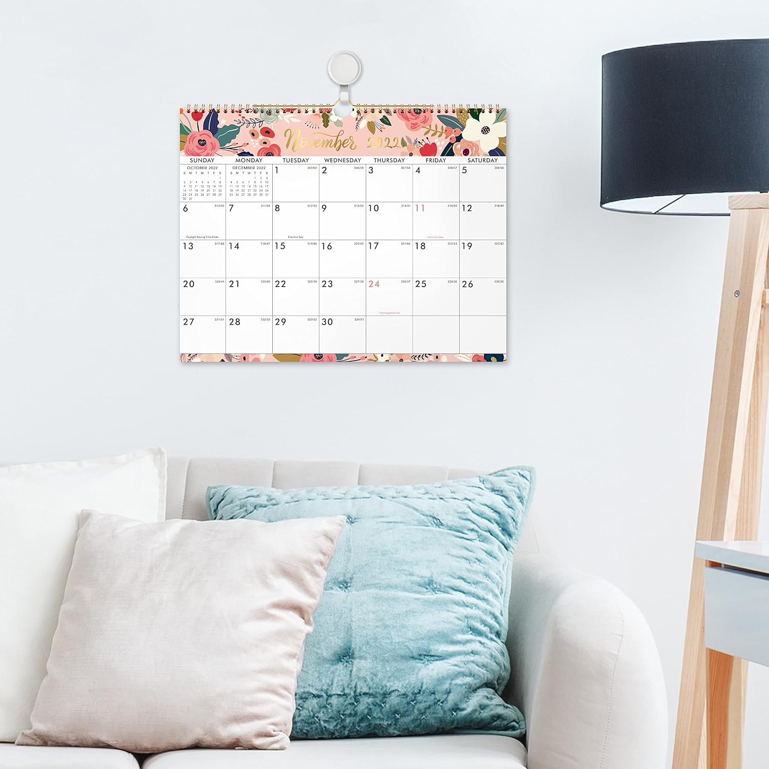 Colorful wall calendar displayed above a sofa beside a floor lamp